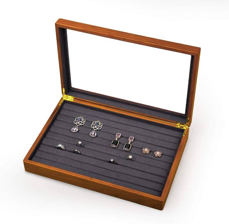 Wooden jewelry box with a clear glass lid and multiple padded slots for organizing rings and earrings.
